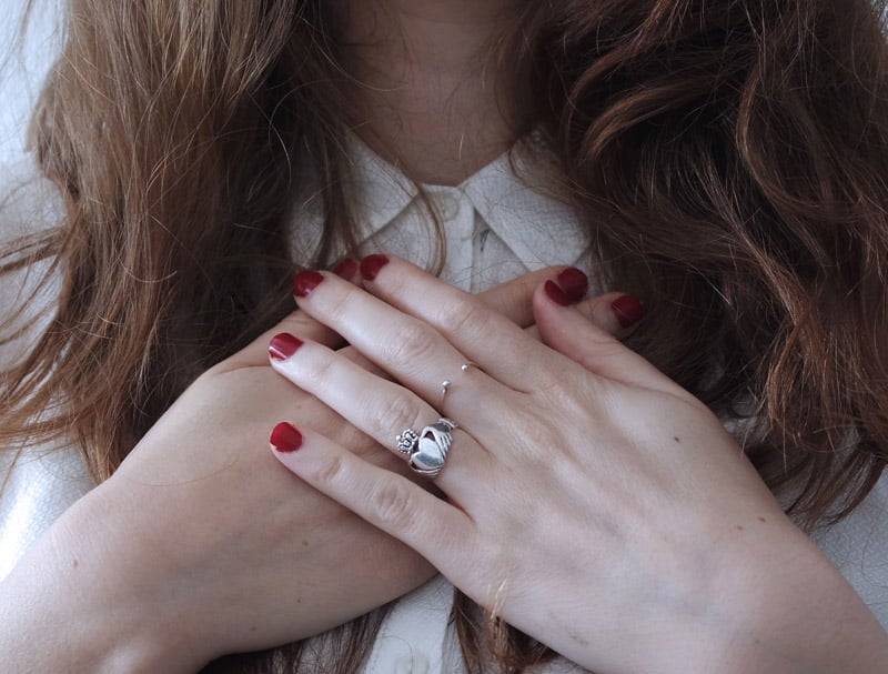 A woman with her hands covering her heart